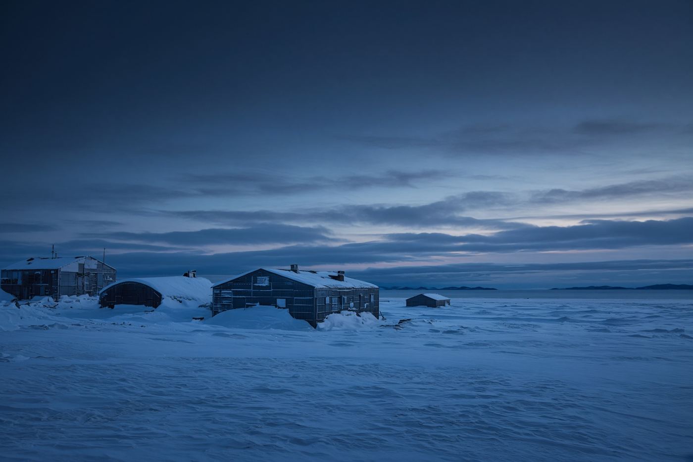A snowbound station under a pale horizon